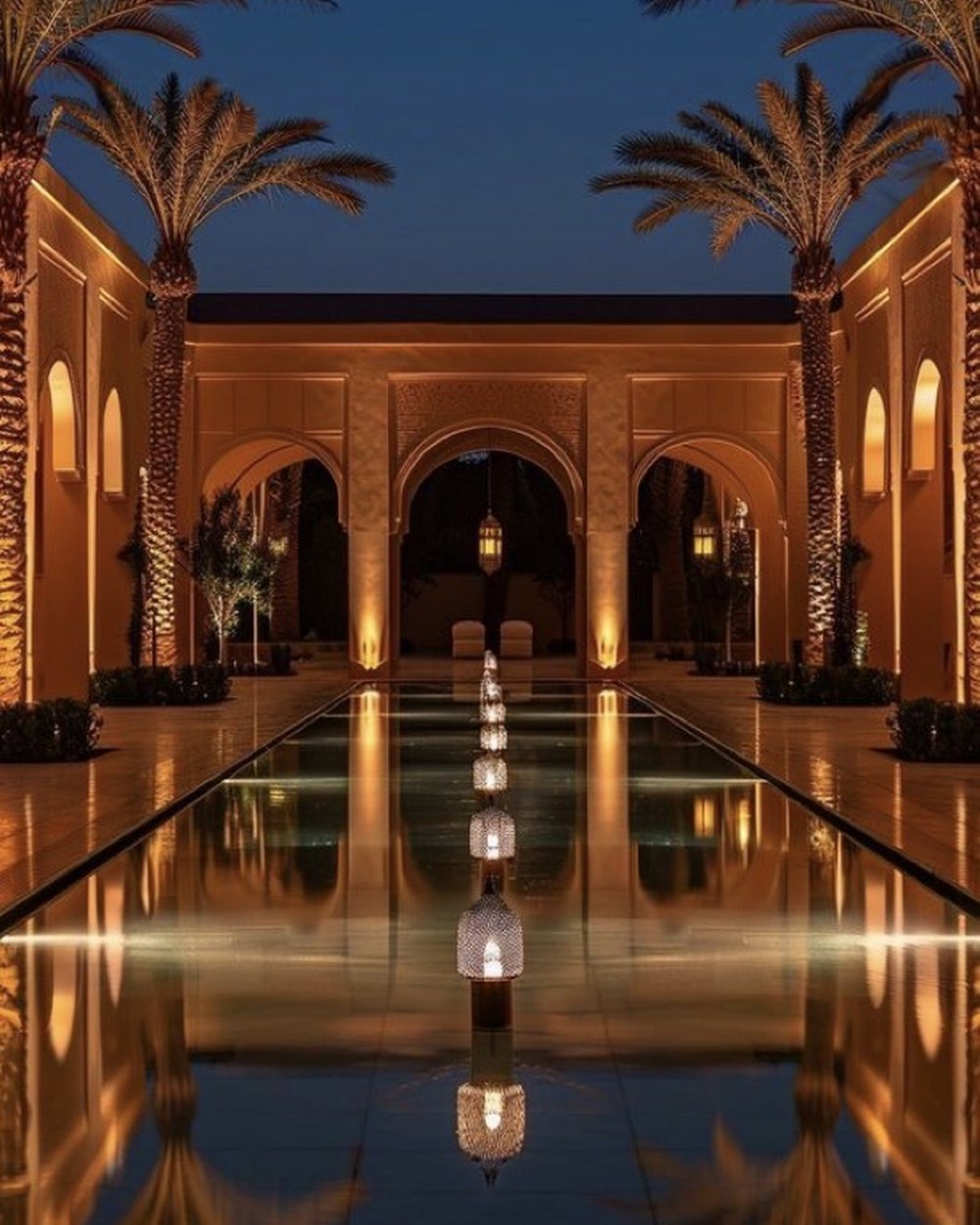 Riad marocain contemporain illuminé à la nuit tombée